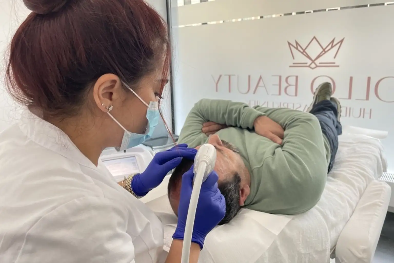 Huidtherapeut voert Mesotherapie behandeling haargroei uit bij mannelijke cliënt.