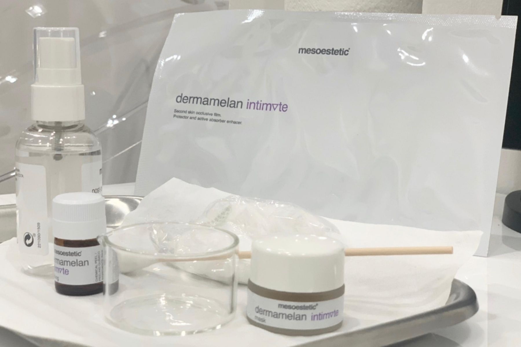 Set mesoestetic dermamelan intimate huidbehandelingsproducten op een dienblad.