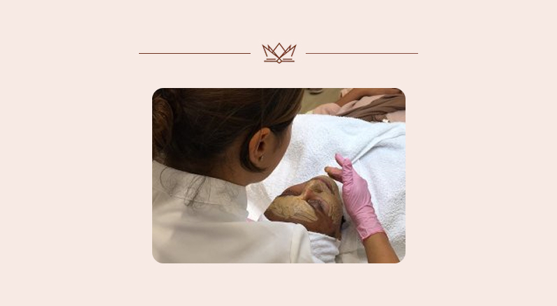 Specialist brengt Dermamelan masker aan tijdens behandeling.