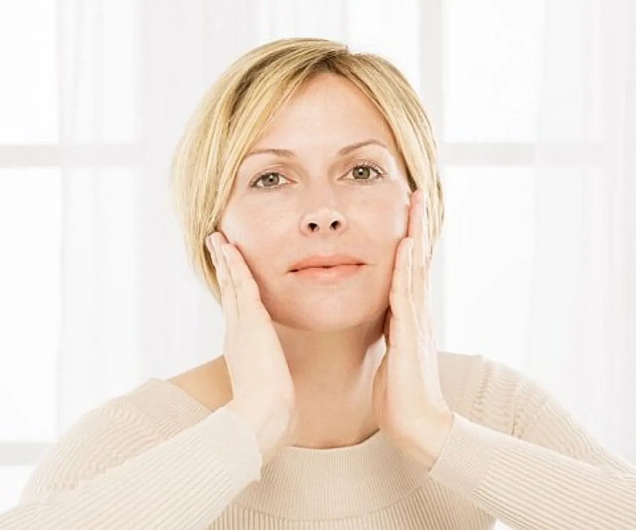 Vrouw bekijkt haar huid in het licht, symbool voor huidverbetering en verjonging bij Apollo Beauty Rotterdam.